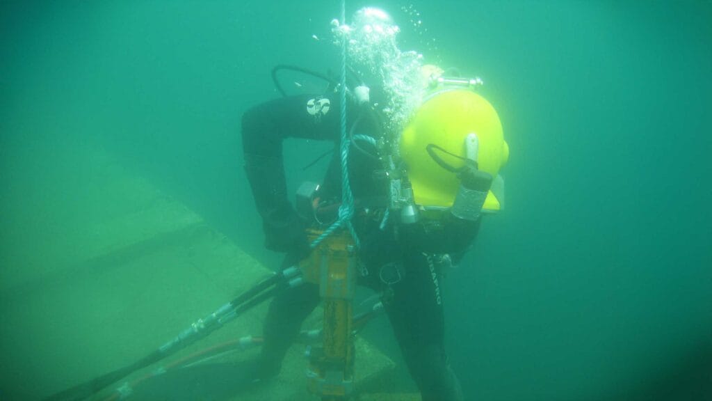 Diver at work setting anchor bold for oyster beds.